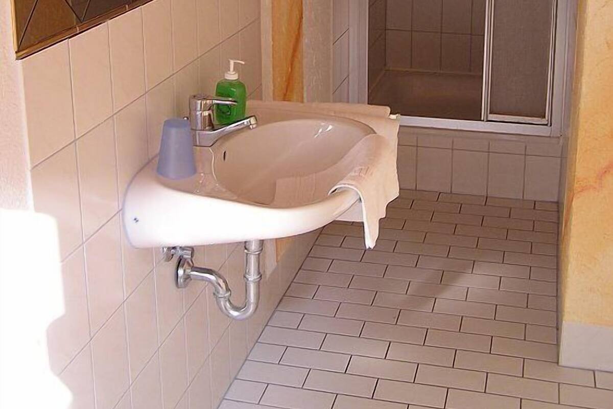 A bathroom with a freestanding bathtub, a mirror, and a shower enclosure.