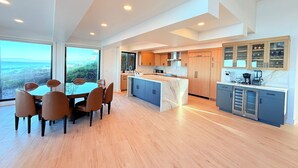 Una cocina moderna con una isla central, armarios de madera y una zona de comedor con mesa y sillas.