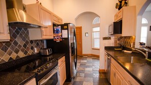 A kitchen with a stove, oven, refrigerator, microwave, and sink. - Kodiak, Alaska Executive Home  (Kodiak)