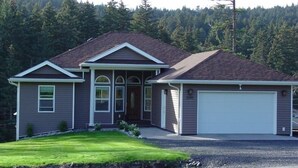A single-story house with a garage, a front porch, and a well-maintained lawn. - Kodiak, Alaska Executive Home  (Kodiak)
