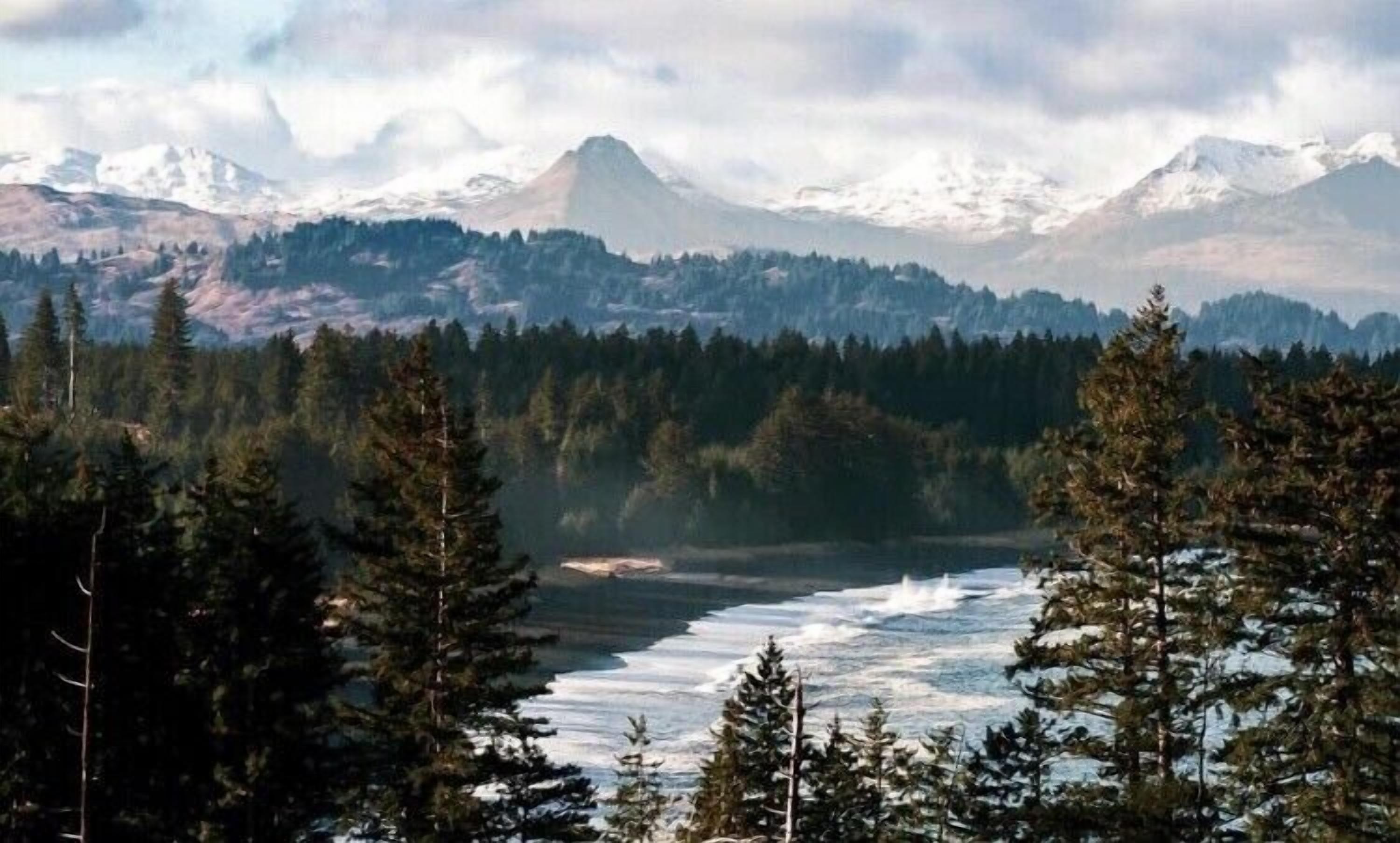 A mountainous landscape with dense forests and a river.