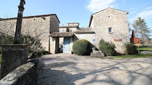A stone building with a traditional tiled roof, a small door, and a sign indicating a restaurant and hotel. - La Bastide du Vebron (Grospierres)