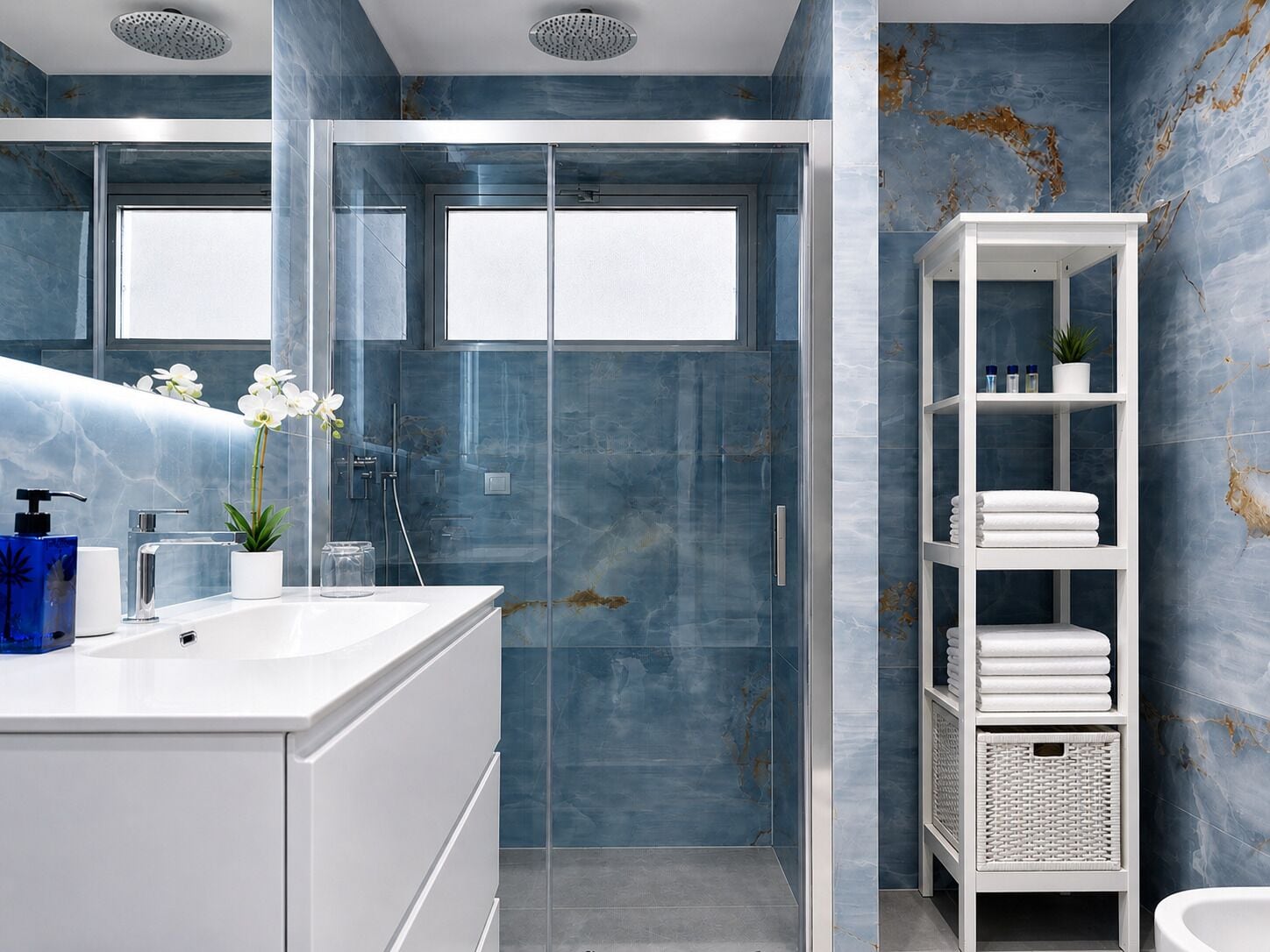 A modern bathroom with a glass shower enclosure, a white vanity with a sink, and a white shelving unit with towels.