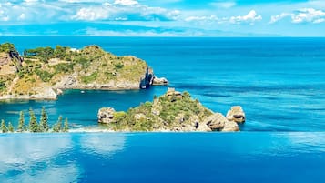 A coastal landscape with rocky outcrops and clear blue waters.