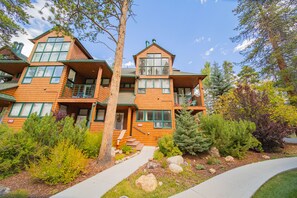 A multi-story wooden building with a balcony, surrounded by landscaped gardens and trees. - Soda Spring II 1927 (Keystone)