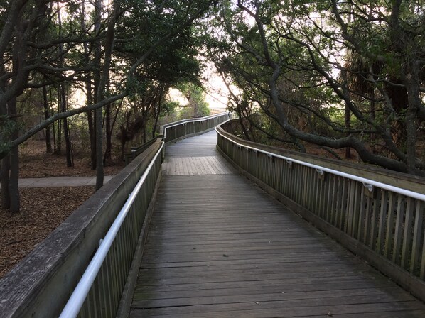 A wooden boardwalk through a forested area with metal railings on both sides. - Grace Meadows: 3BR/3BA, close To Westin, Beach, Golf & Tennis (Hilton Head Island)