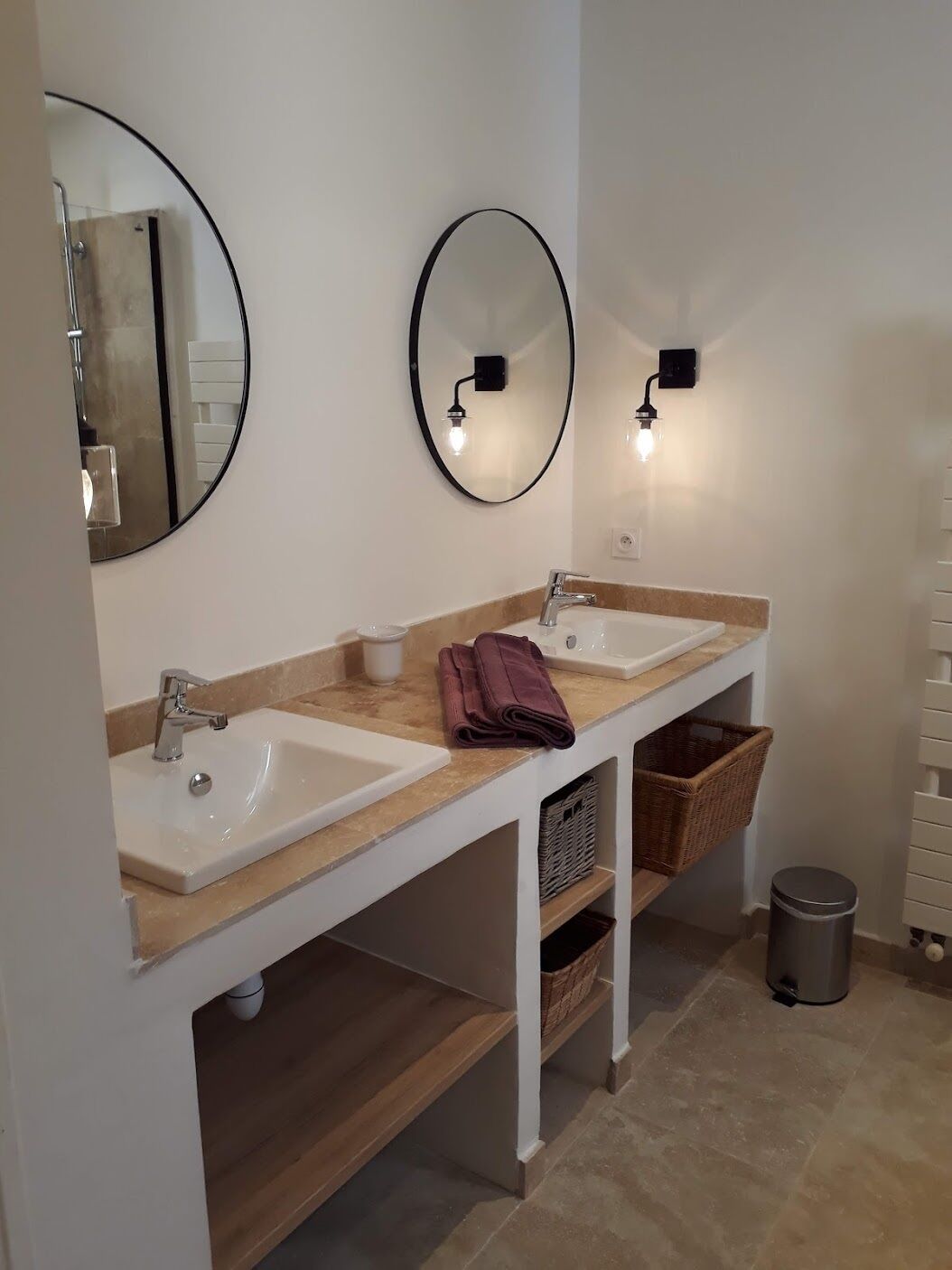A bathroom with two sinks, a mirror, and a towel rack.