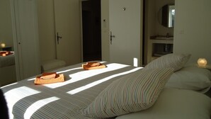 Ein Schlafzimmer mit Bett, Nachttisch, Spiegel und Kleiderschrank.