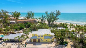 Una proprietà costiera con una casa grande, diversi edifici e vista sulla spiaggia.