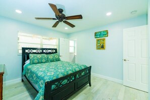 A bedroom with a bed, a ceiling fan, and a door. - Comforts of Home in Condo w/ Pool a Block from Siesta Key Village, Pet Friendly (Sarasota)