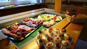 Un bufé con una variedad de alimentos, incluyendo carnes, quesos y aperitivos.