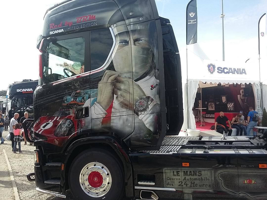 Een grote vrachtwagen met een gedetailleerde reclame op de zijkant.