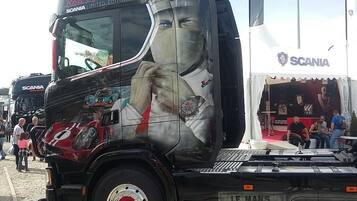 Een grote vrachtwagen met een gedetailleerde reclame op de zijkant.