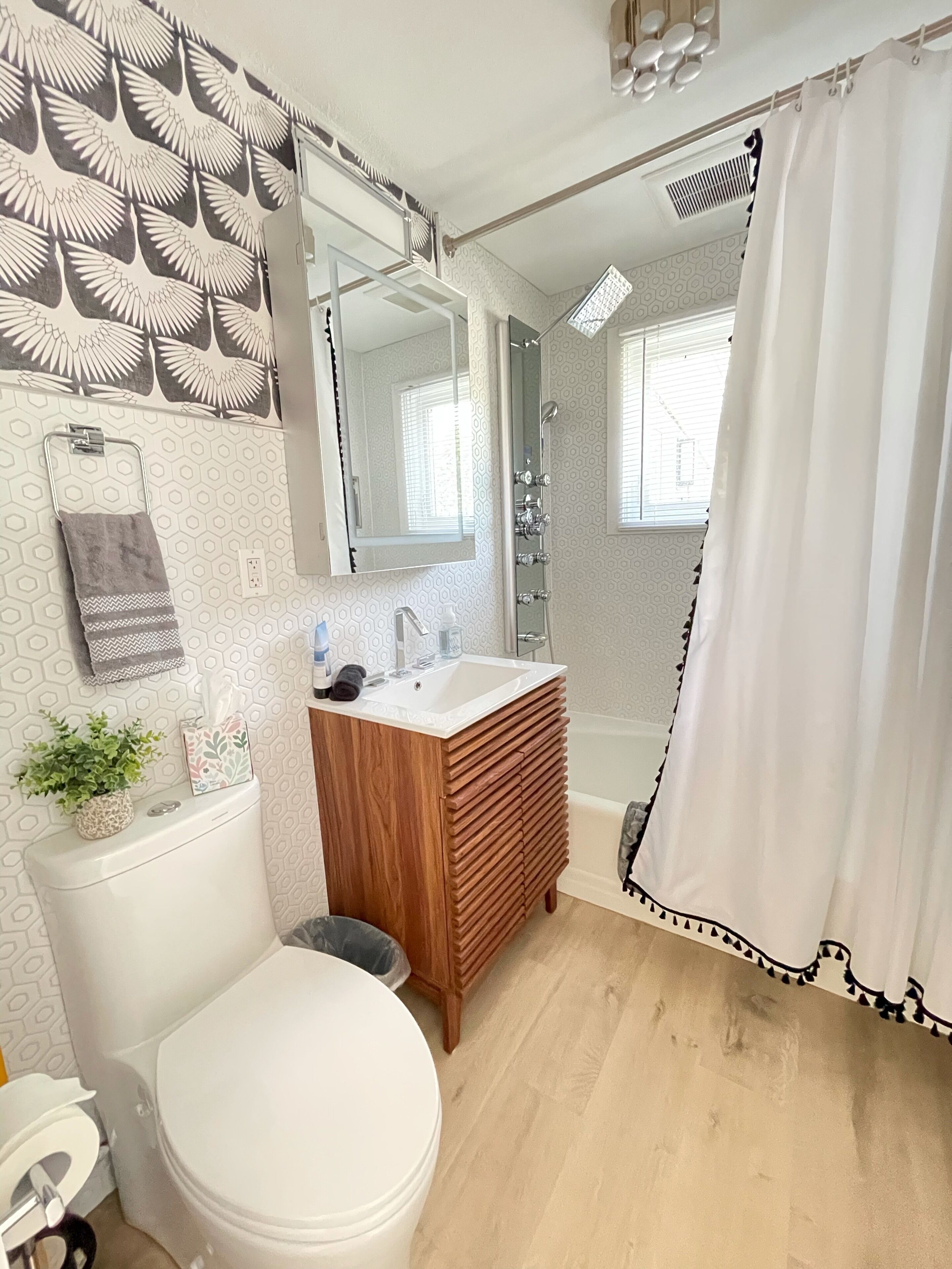 A bathroom with a toilet, sink, and shower.