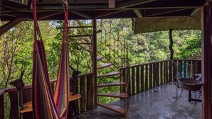 A wooden staircase leading to a balcony with a hammock and a metal chair. - Treetop House - Charming Artistic in the Canopy of Monteverde (Monteverde)