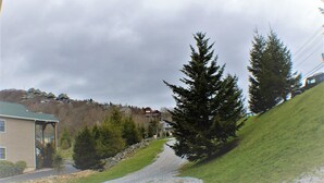 A residential street with houses, a gravel path, and a hill with trees. - Large Group bunkroom sleeps up to 69 (Beech Mountain)