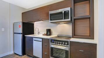 A modern kitchen with a stainless steel refrigerator, a microwave, an oven, and a dishwasher.