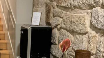 Ein Empfangsbereich mit Steinwand, einem schwarzen Server, einer Vase mit einer Blume und einem gerahmten Schild.