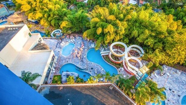 An aerial view of a resort with multiple swimming pools, water slides, and lush greenery. - Golden Dolphin Grand Hotel - Mondial (Caldas Novas)