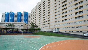 A multi-story residential building with a sports court in the foreground. - Golden Dolphin Grand Hotel - Mondial (Caldas Novas)