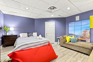 A bedroom with a bed, a dresser, a sofa, and a large window with a cityscape view. - Luxury Lake House, Pool, Hot tub, Dock, Beach, Game room, Boat Rental available (Charlotte)