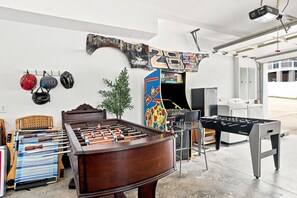 A room with a foosball table, a ping pong table, and a wall-mounted foosball table. - Luxury Lake House, Pool, Hot tub, Dock, Beach, Game room, Boat Rental available (Charlotte)