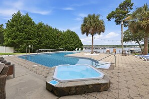 A swimming pool area with lounge chairs and a hot tub. - Luxury Lake House, Pool, Hot tub, Dock, Beach, Game room, Boat Rental available (Charlotte)