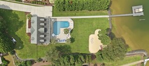 A large building with a swimming pool, a covered patio, and a boat dock. - Luxury Lake House, Pool, Hot tub, Dock, Beach, Game room, Boat Rental available (Charlotte)