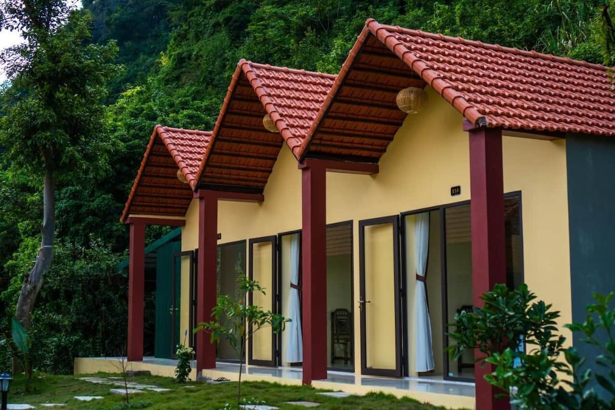 A row of single-story buildings with red-tiled roofs and large sliding glass doors.