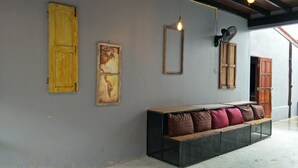 Una habitación con un banco, un mapa en la pared y un ventilador.
