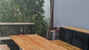 Un área de patio al aire libre con una larga mesa de madera y varias sillas.
