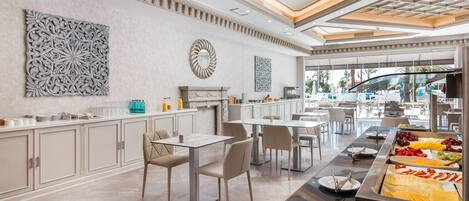 A modern hotel dining area with a buffet, white cabinets, and contemporary decor.