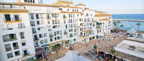 A hotel with multiple floors, balconies, and a central courtyard with shops and outdoor seating.