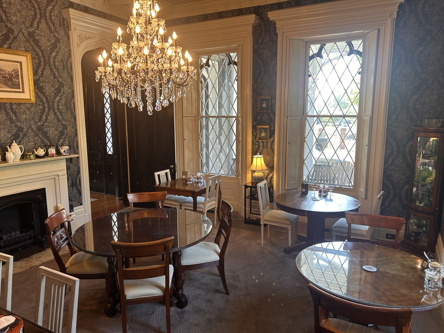 Uma sala de jantar com candelabro, lareira e janelas amplas com vista.