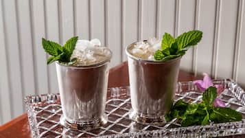 Deux verres de boisson glacée, décorés de feuilles de menthe, sont posés sur un plateau en verre.