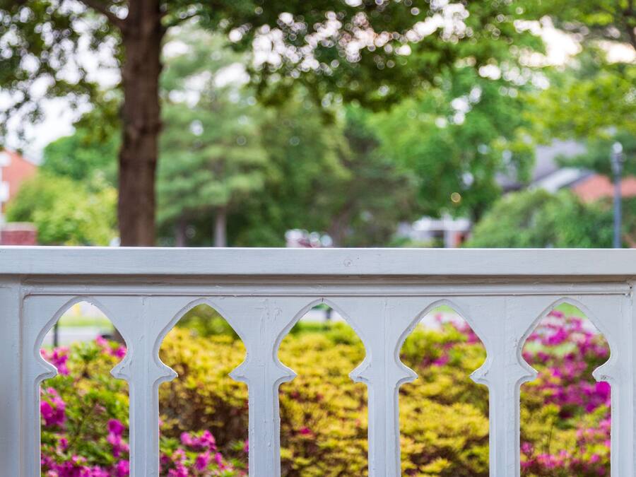 A white wooden fence with decorative cutouts.