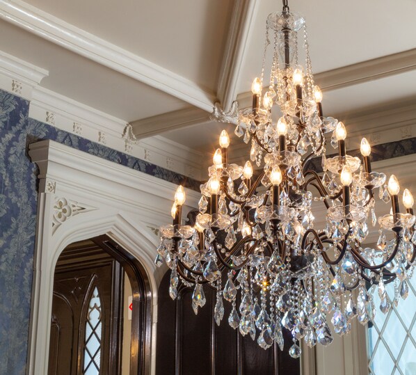 A chandelier with multiple lights and crystal decorations. - Inn at Woodhaven (Louisville)