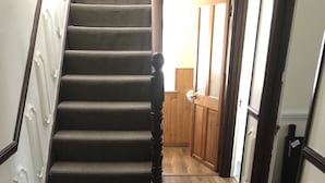 A wooden staircase with a carpeted landing area leading to a room with wooden flooring. - The Rhinos 2 (Enfield)