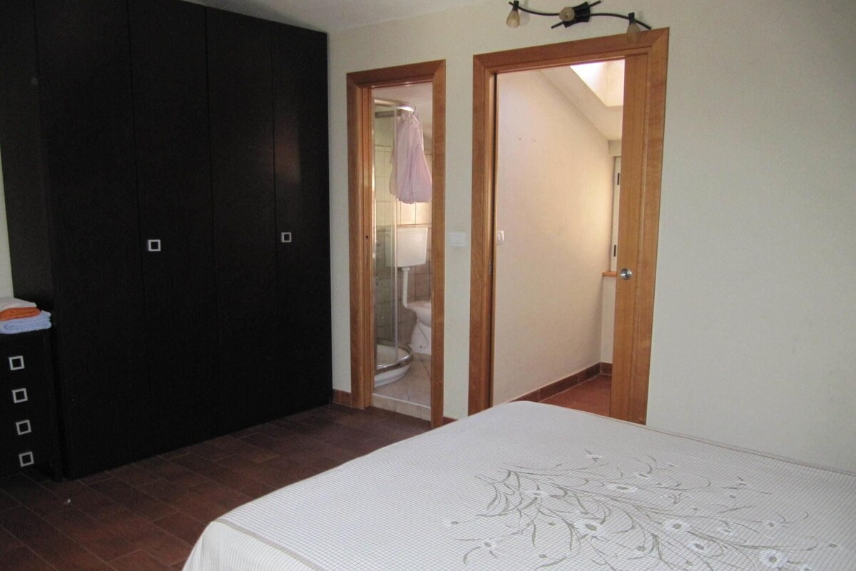 Un dormitorio con una cama, un armario y dos puertas que dan a otras habitaciones.