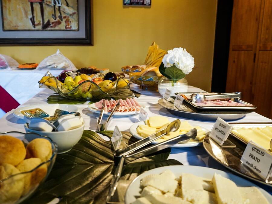 A buffet table with various food items including fruits, cheeses, and meats.