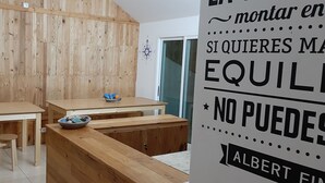 Un interior de madera con una zona de cocina que incluye una barra larga, taburetes y una pared decorativa con una brújula.