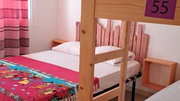 Un dormitorio con literas, las número 55 y 66, y una ventana con cortinas rosadas.