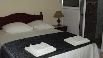 Habitación estándar, 1 cama matrimonial | Espacio para trabajar con laptop y tabla de planchar con plancha