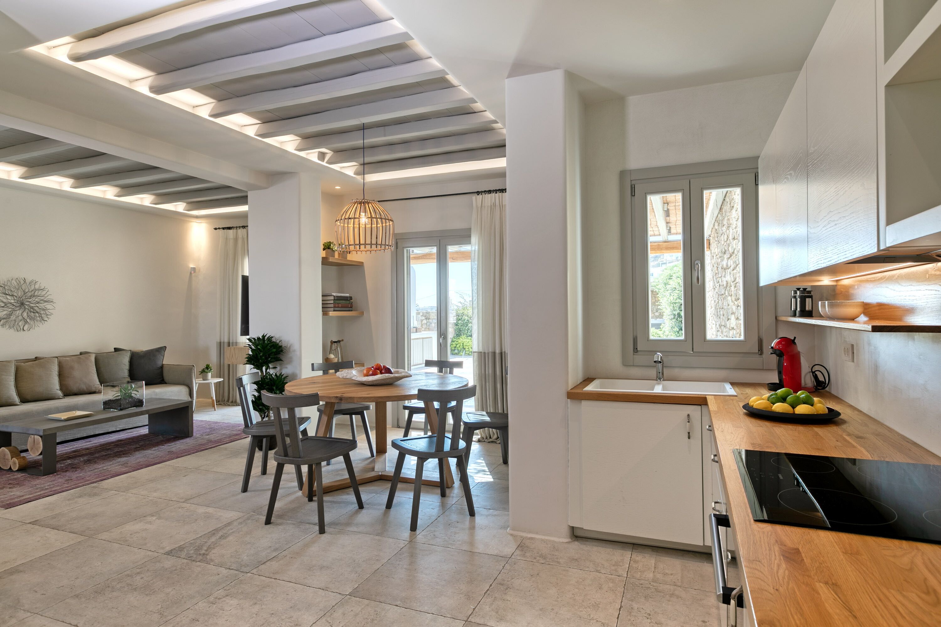A modern kitchen with a wooden countertop, a built-in stove, and a window above the sink.