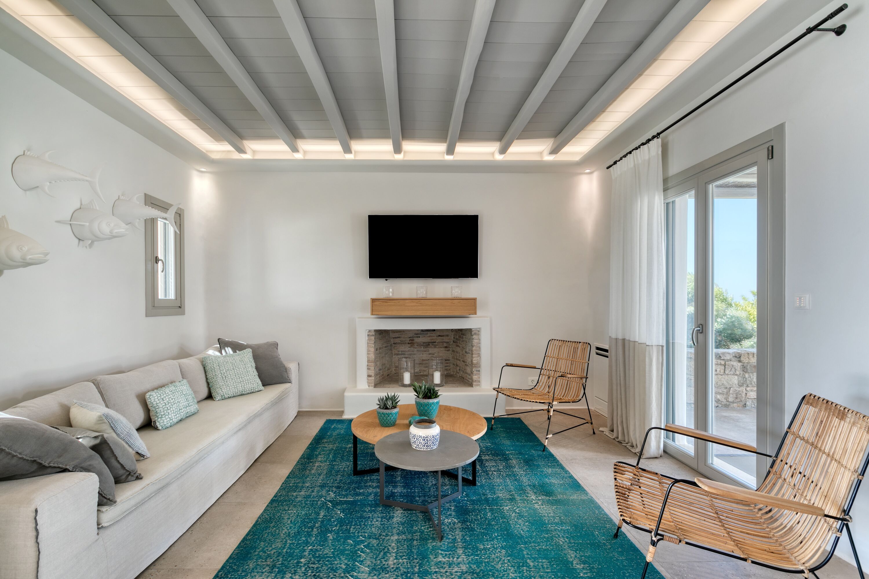 A modern living room with a sofa, a coffee table, and a fireplace.