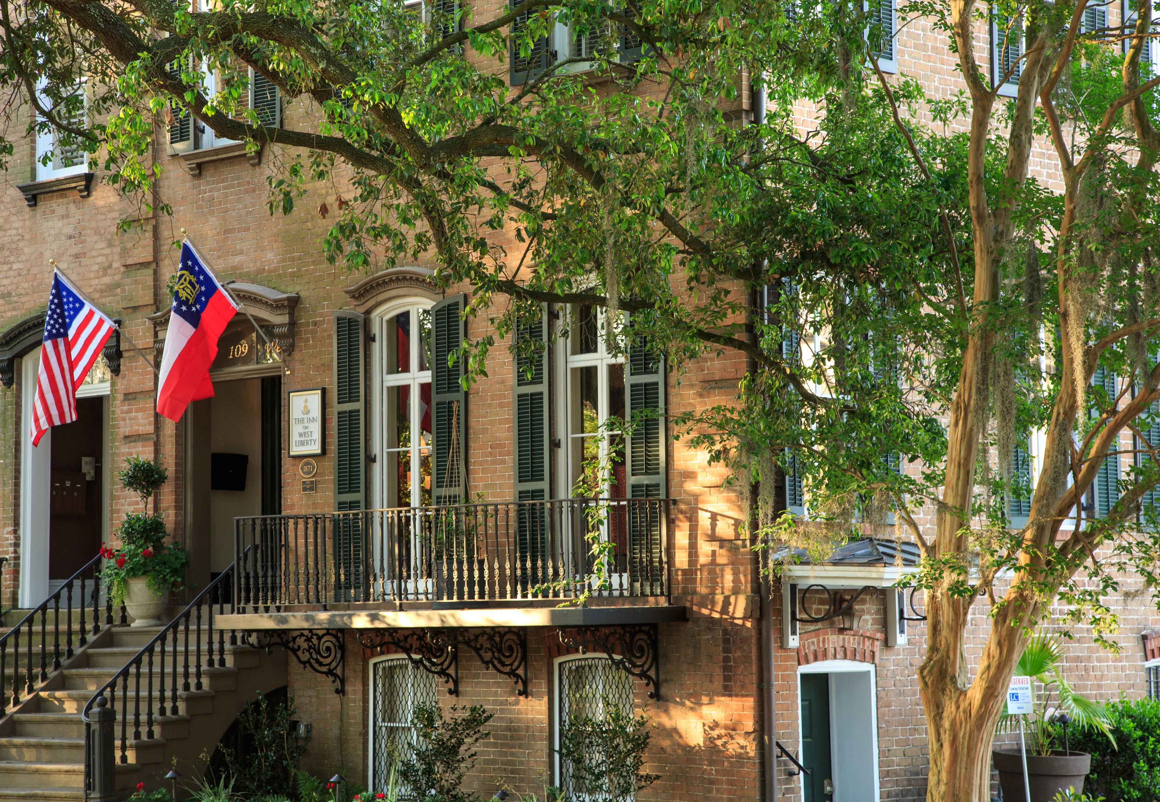 Un bâtiment en briques doté d’un balcon, de deux drapeaux et d’un escalier.