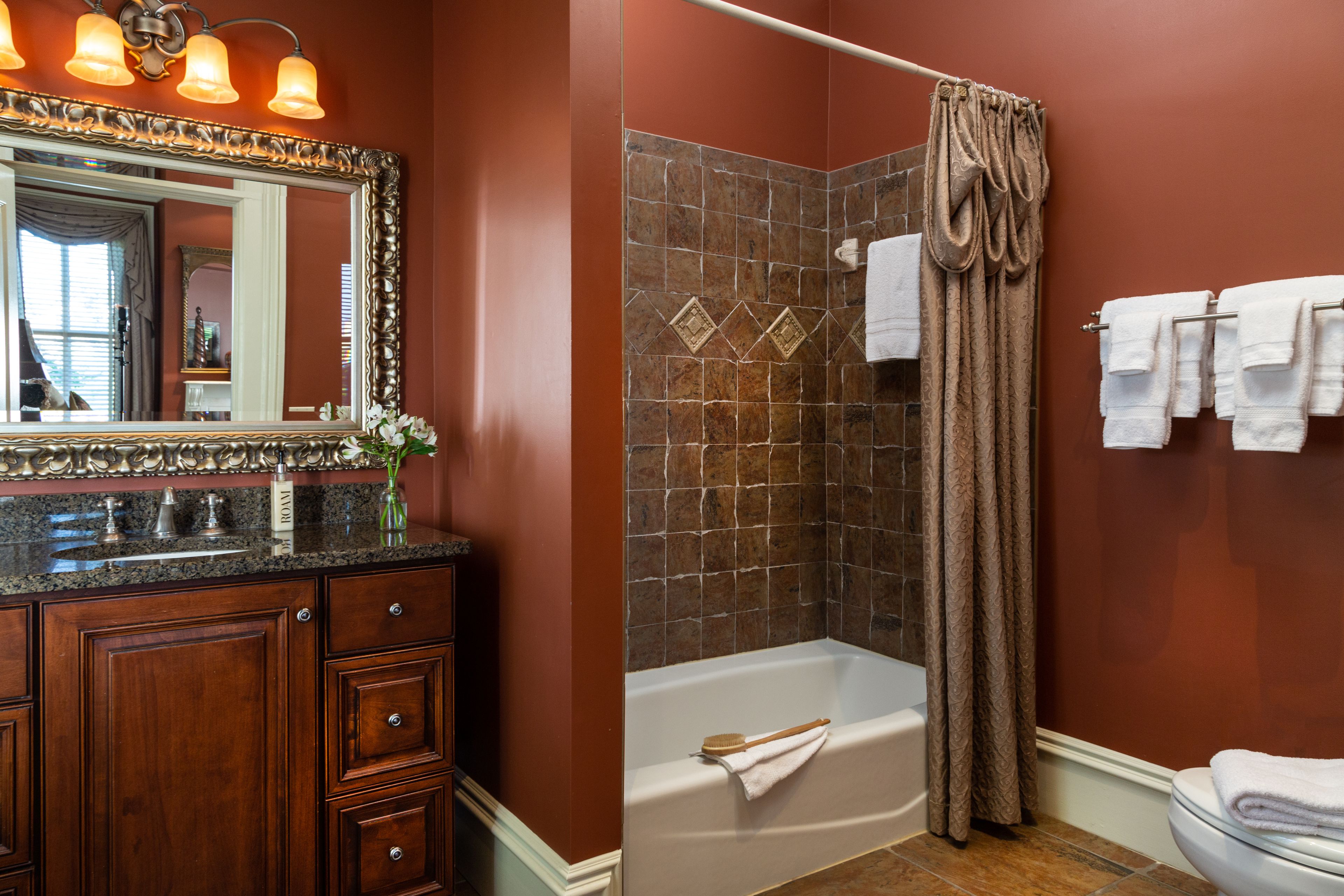 A bathroom with a vanity, a bathtub, and a shower curtain.
