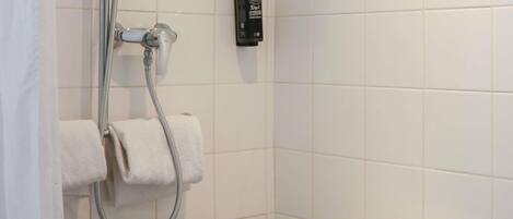 A bathroom with a shower, a toilet, and a towel rack.
