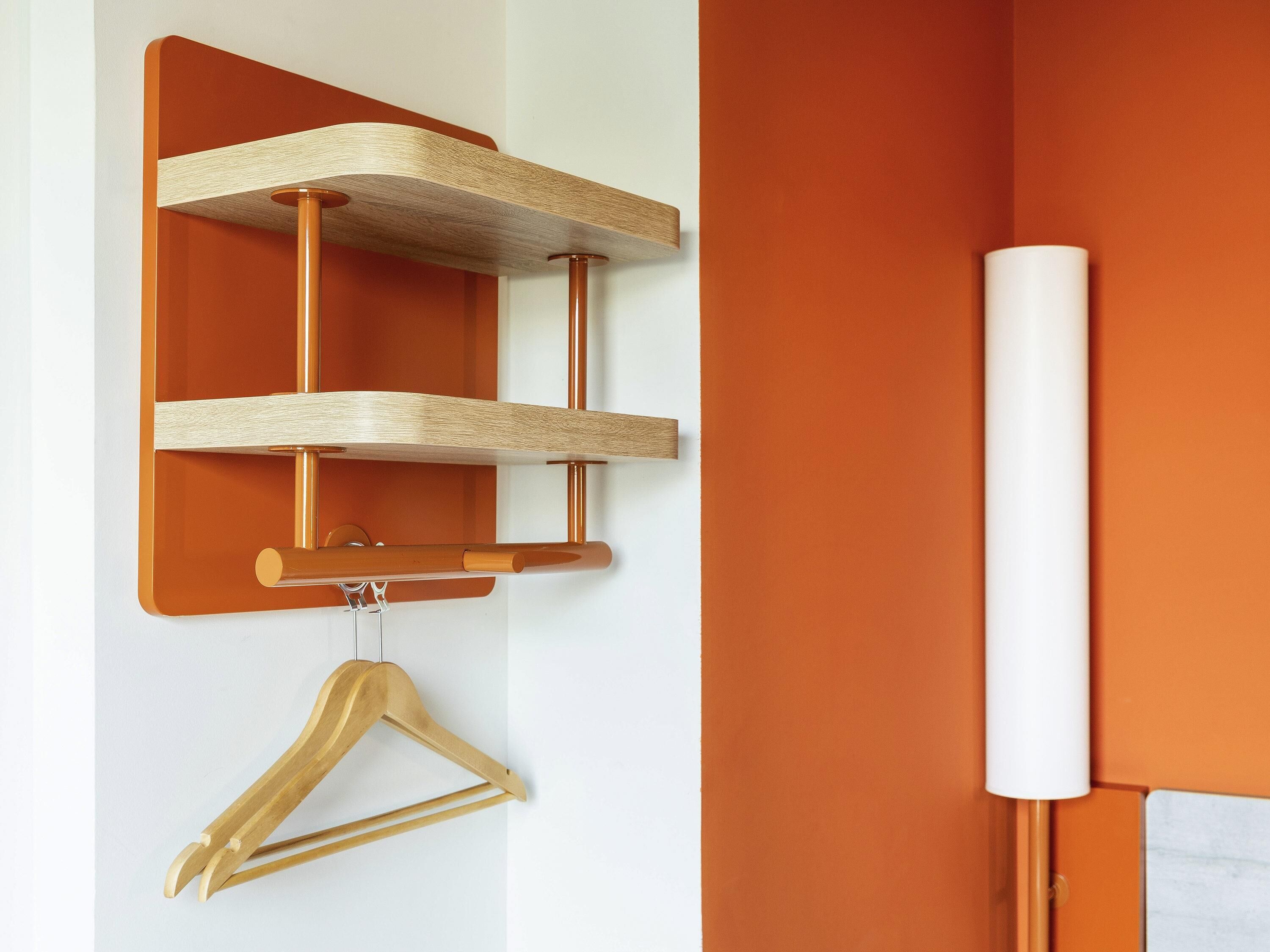 Een houten wandplank met een ophanghaak voor kleding.