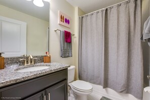 Une salle de bain avec un meuble-lavabo à deux vasques, des toilettes et une baignoire.